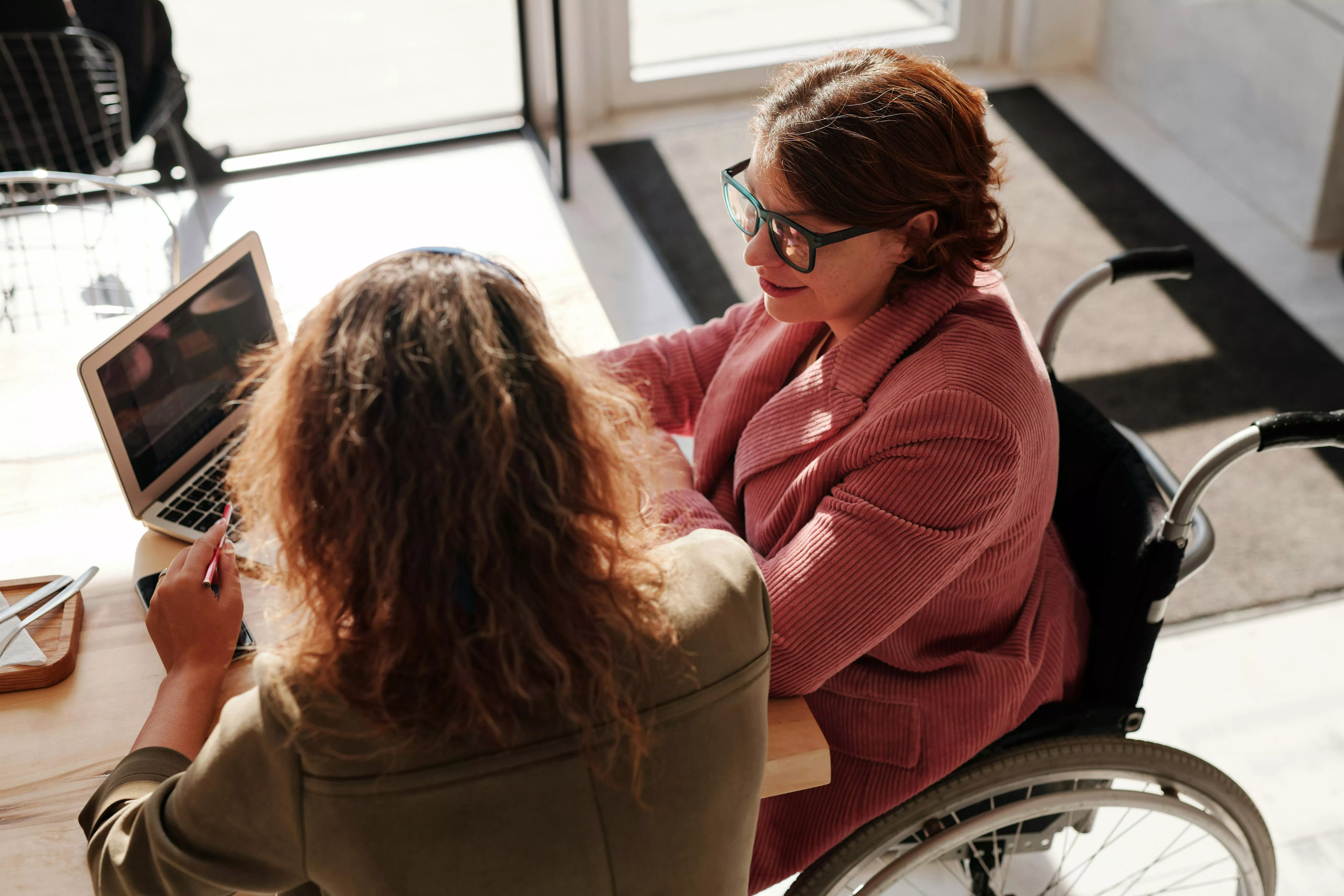 A photo of two people working on a laptop together.