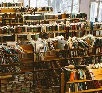 Photo of a bunch of shelves of books in a library.