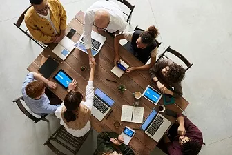 Photo of a group of people meeting around a table.